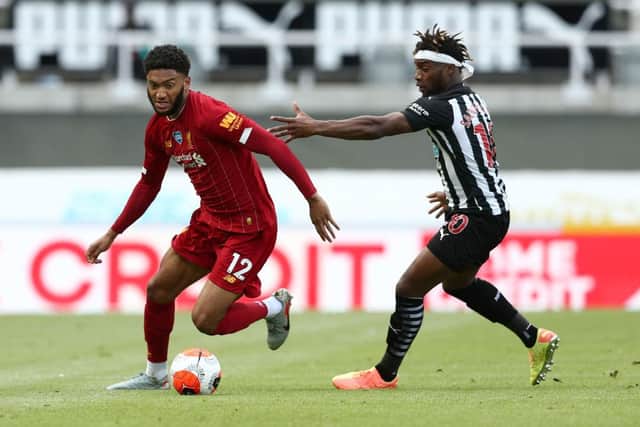 NEWCASTLE UPON TYNE, ENGLAND - JULY 26: Joe Gomez of Liverpool runs with the ball under pressure from Allan Saint-Maximin of Newcastle United during the Premier League match between Newcastle United and Liverpool FC at St. James Park on July 26, 2020 in Newcastle upon Tyne, England.