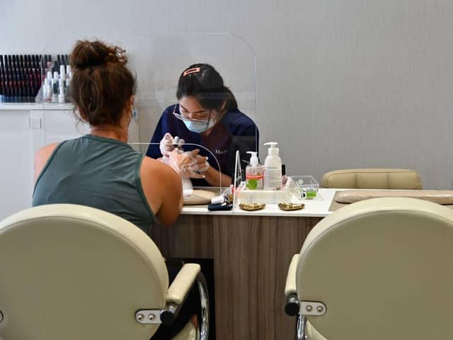 A client receives a manicure at a nail salon. Salons are allowed to reopen in England from today (Photo by ANGELA WEISS/AFP via Getty Images)