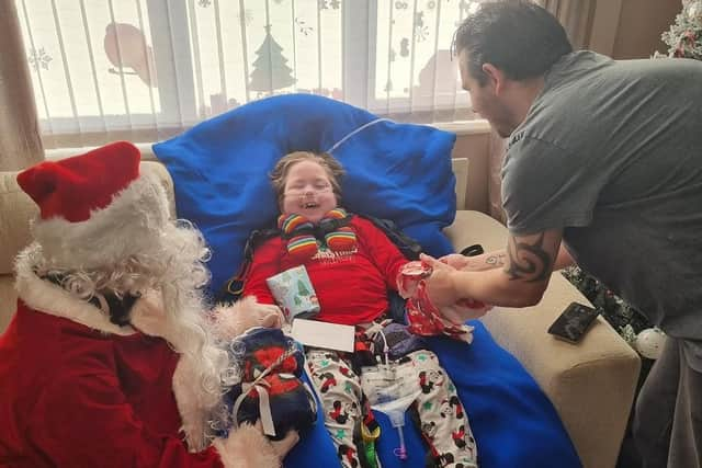 Dad Stephen joins Milo in welcoming Santa to their home.