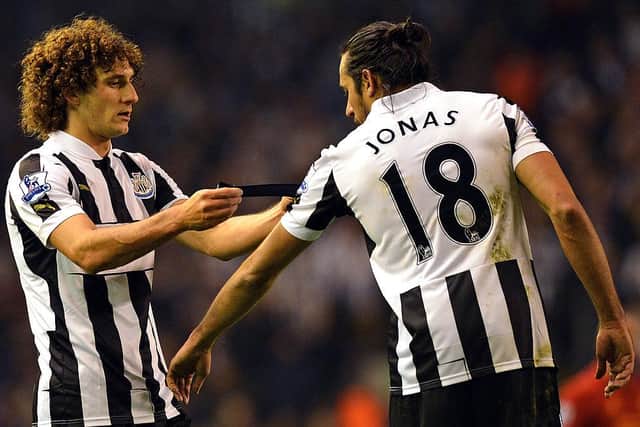 Fabricio Coloccini passes the captain's armband to close friend Jonas Gutierrez after being sent off at Anfield in 2012.