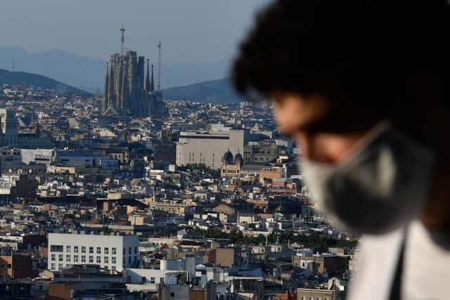 A man wearing a face mask sits at a terrace bar overlooking the Sagrada Familia in Barcelona on July 25, 2020. - The Catalan government ordered the closure of all nightclubs, discos and event halls across this region of northeastern Spain following a surge in cases of coronavirus. (Photo by Pau BARRENA / AFP via Getty Images)