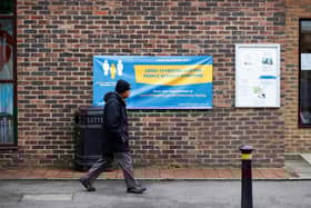 A man walks past a banner featuring a coronavirus testing site set up at St Mary's Church hall in the London borough of Hillingdon, England on May 14, 2021, as part of surge testing to monitor and suppress the spread of the Covid-19 variant first identified in India. - The Indian coronavirus variant has been detected in a number of areas in England which are reporting the highest rates of infection, data from Public Health England (PHE) suggests. (Photo by Adrian DENNIS / AFP) (Photo by ADRIAN DENNIS/AFP via Getty Images)