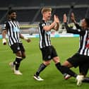 Joe Willock of Newcastle United celebrates with team mate Matt Ritchie after scoring their sides third goal, missing from the penalty spot but scoring the rebound during the Premier League match between Newcastle United and Manchester City at St. James Park on May 14, 2021 in Newcastle upon Tyne, England.