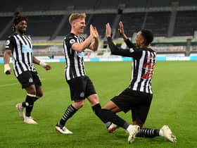 Joe Willock of Newcastle United celebrates with team mate Matt Ritchie after scoring their sides third goal, missing from the penalty spot but scoring the rebound during the Premier League match between Newcastle United and Manchester City at St. James Park on May 14, 2021 in Newcastle upon Tyne, England.