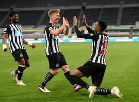 Joe Willock of Newcastle United celebrates with team mate Matt Ritchie after scoring their sides third goal, missing from the penalty spot but scoring the rebound during the Premier League match between Newcastle United and Manchester City at St. James Park on May 14, 2021 in Newcastle upon Tyne, England.