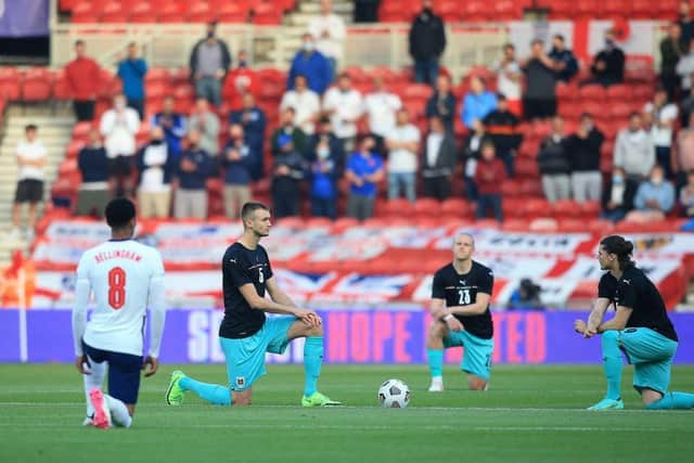 England's midfielder Jude Bellingham (L), Austria's defender Stefan Posch (2L), Austria's midfielder Xaver Schlager (2R) and Austria's striker Marcel Sabitzer take the knee in support of the No Room For Racism campaign ahead of the international friendly football match between England and Austria at the Riverside Stadium.