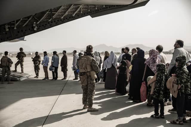 In this image provided by the US Marine Corps, evacuees wait to board a Boeing C-17 Globemaster III during an evacuation at Hamid Karzai International Airport in Kabul, Afghanistan, Monday, Aug. 30. 2021. (Staff Sgt. Victor Mancilla/U.S. Marine Corps via AP)