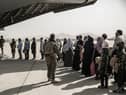 In this image provided by the US Marine Corps, evacuees wait to board a Boeing C-17 Globemaster III during an evacuation at Hamid Karzai International Airport in Kabul, Afghanistan, Monday, Aug. 30. 2021. (Staff Sgt. Victor Mancilla/U.S. Marine Corps via AP)