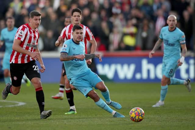 Bruno Guimaraes of Newcastle United runs with the ball from Vitaly Janelt of Brentford during the Premier League match between Brentford and Newcastle United at Brentford Community Stadium on February 26, 2022 in Brentford, England. (Photo by Luke Walker/Getty Images)