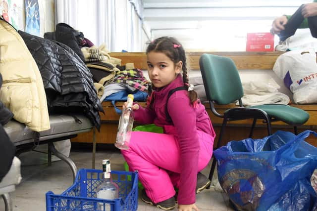 A small girl sorts empty bottles for 'Molotov cocktails' at a humanitarian centre in the western Ukrainian city of Lviv on February 27, 2022. (Photo by YURIY DYACHYSHYN/AFP via Getty Images)