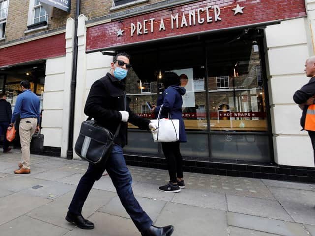 A man wearing PPE (personal protective equipment) passes customers queuing to enter a recently re-opened Pret-A-Manger shop which had originally closed-down due to the COVID-19 pandemic in London (Photo: TOLGA AKMEN/AFP via Getty Images)