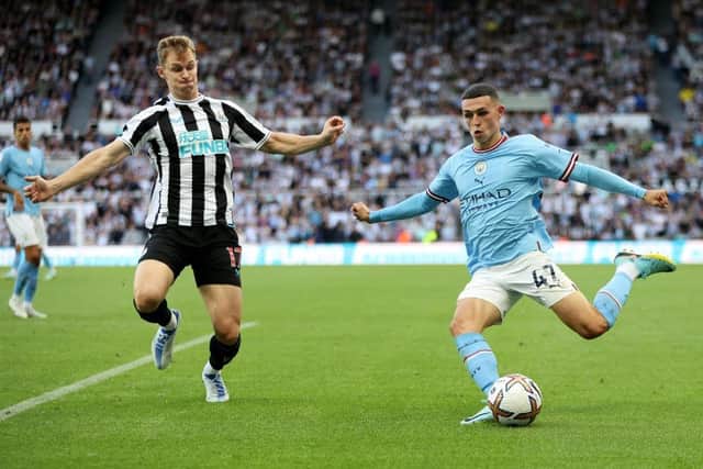 Phil Foden of Manchester City attempts to cross the ball past Emil Krafth of Newcastle United during the Premier League match between Newcastle United and Manchester City at St. James Park on August 21, 2022 in Newcastle upon Tyne, England. (Photo by Clive Brunskill/Getty Images)