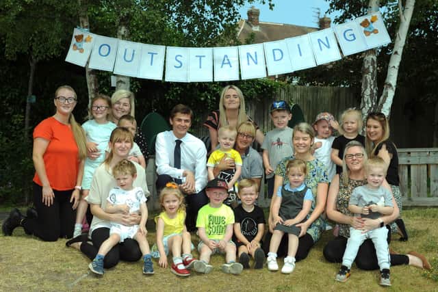 Stanley's at Bede nursery manager Kate Garrity, children and staff, celebrate their Outstanding rated Ofsted report, with Councillor Adam Ellison (tie and white shirt).