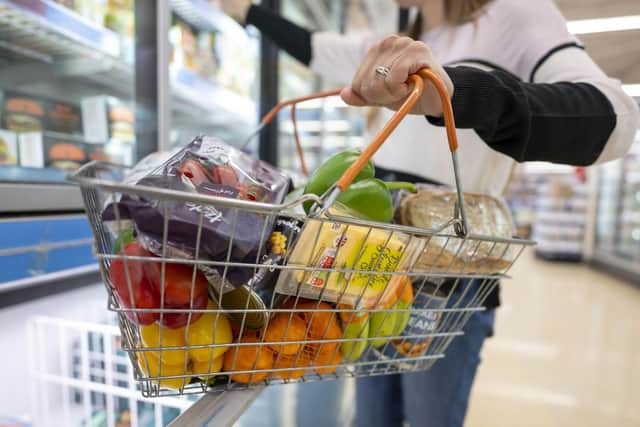 A woman holds a basket of goods in a supermarket as figures show prices on some goods are up by 10% year on year (Photo by Matthew Horwood/Getty Images)