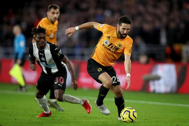 Joao Moutinho of Wolverhampton Wanderers in action with Christian Atsu of Newcastle United.