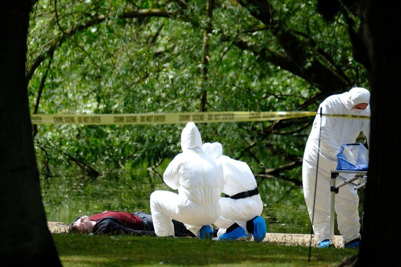 Actors dressed as scene of crime officers examine a 'body'