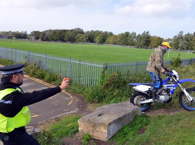 A Northumbria Police officer tests out a DNA spray as Pc Mike 'Spike' Fisher rides by.