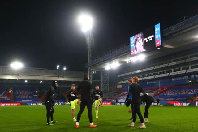 Elliot Anderson, centre, warms up with Newcastle United's substitutes at Selhurst Park.