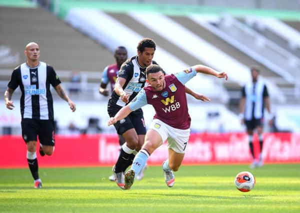 John McGinn of Aston Villa breaks away from Isaac Hayden of Newcastle United.