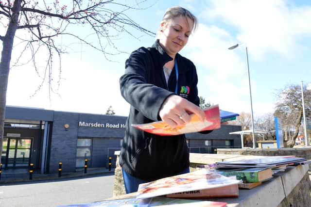 Groundwork's Natalie Currer stacks free books outside Marsden Road Health Centre .