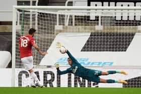Karl Darlow stops a penalty from Bruno Fernandes.