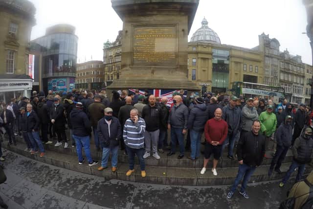 A group gathers at Greys Monument with a Union Jack flag reading Defenders of Newcastle. Photo Credit: North News and Pictures