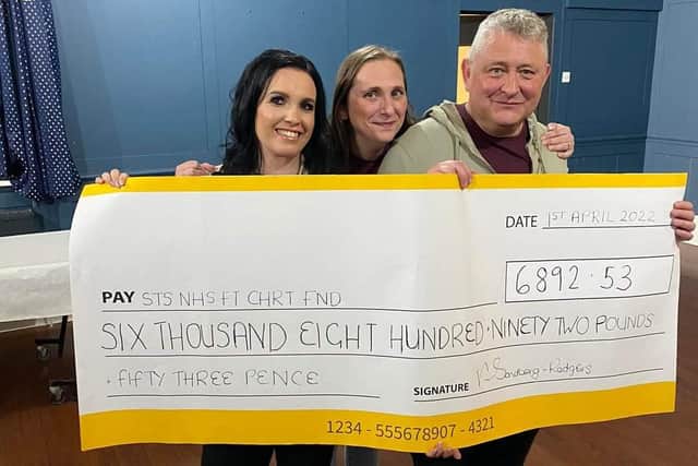Mensi's daughter, Victoria Sandberg-Rodgers, left, shows off the amount raised with promoters Sam Connor and John Connor.