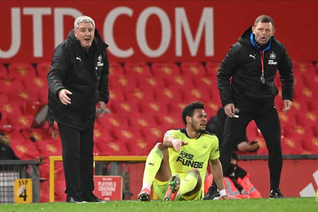 Newcastle manager Steve Bruce (l) and coach Graeme Jones look on as 'striker Joelinton reacts after going to ground during the Premier League match between Manchester United and Newcastle United at Old Trafford on February 21, 2021 in Manchester, England.