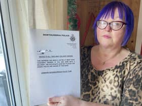 Diane Maines holding a sign she has placed inside a window of her Hebburn home. Picture by FRANK REID