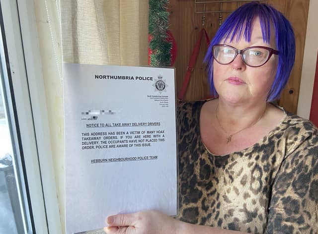 Diane Maines holding a sign she has placed inside a window of her Hebburn home. Picture by FRANK REID