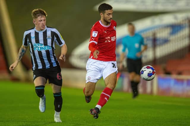 Barnsley's Ziyad Larkeche holds off Newcastle United's Jay Turner-Cooke.