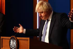 Prime Minister Boris Johnson gestures whilst speaking at a press conference in London's Downing Street after ministers met to consider imposing new restrictions in response to rising cases and the spread of the Omicron variant. Picture date: Wednesday December 8, 2021.