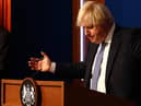 Prime Minister Boris Johnson gestures whilst speaking at a press conference in London's Downing Street after ministers met to consider imposing new restrictions in response to rising cases and the spread of the Omicron variant. Picture date: Wednesday December 8, 2021.