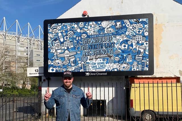 Illustrator James Dixon with a billboard design he did for the NHS