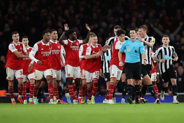 Arsenal players surround the Referee Andy Madley after a late penalty appeal during the Premier League match between Arsenal FC and Newcastle United at Emirates Stadium on January 03, 2023 in London, England. (Photo by Julian Finney/Getty Images)