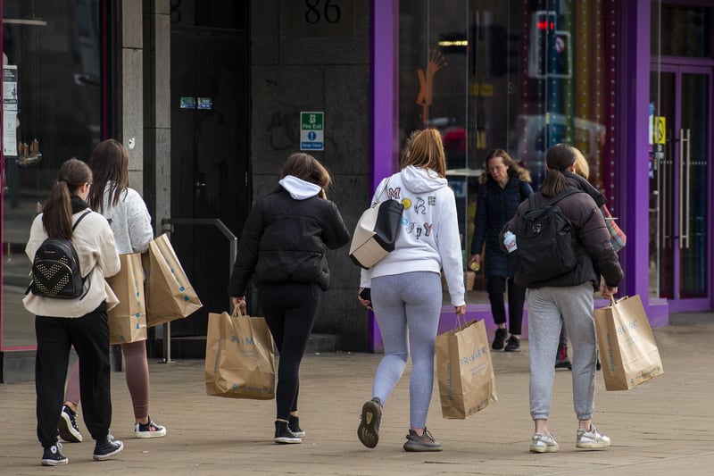 Shoppers pictured carrying Primark bags on Monday morning after they have visited the store for the first time in months.