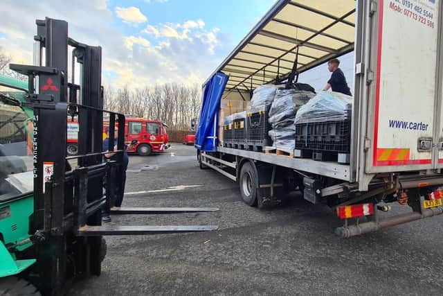 Staff at Tony Carter Transport Limited loading fire equipment onto lorry at TWFRS Stores warehouse