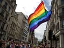 A rainbow flag being held aloft.