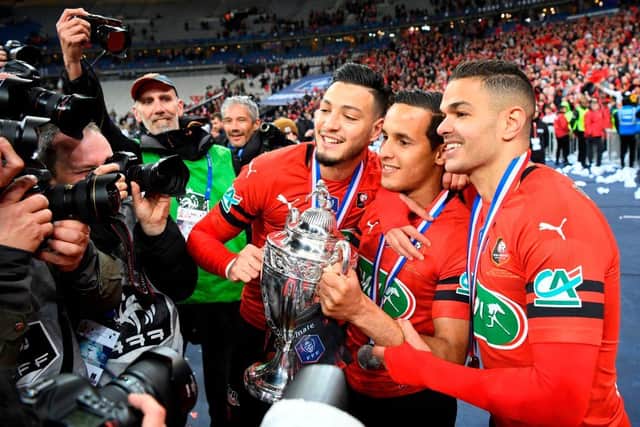 Rennes' Algerian defender Ramy Bensebaini, Algerian defender Mehdi Zeffane and French forward Hatem Ben Arfa celebrate with the trophy after winning the French Cup final football match between Rennes (SRFC) and Paris Saint-Germain (PSG), on April 27, 2019 at the Stade de France in Saint-Denis, outside Paris. (Photo by Damien MEYER / AFP) (Photo credit should read DAMIEN MEYER/AFP via Getty Images)