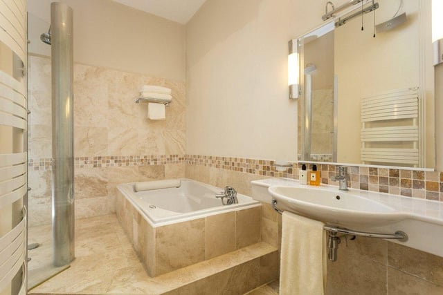 Three bathrooms are located throughout, including a house bathroom which is modern in style and features a bath, shower, heated towel rail and Travertine tiled floor.