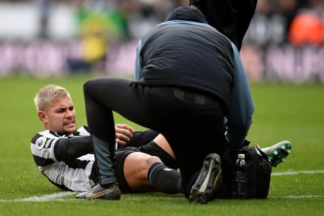 Newcastle United midfielder Bruno Guimaraes receives medical treatment.