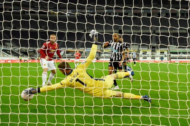 Manchester United goalkeeper David de Gea makes a superb save from a shot from Callum Wilson (r) during the Premier League match between Newcastle United and Manchester United at St. James Park on October 17, 2020 in Newcastle upon Tyne, England.