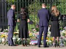 Prince Harry, Duke of Sussex, Meghan, Duchess of Sussex, Prince William, Prince of Wales, and Catherine, Princess of Wales, look at floral tributes laid by members of the public at Windsor Castle on September 10. Picture: Chris Jackson/Getty Images.
