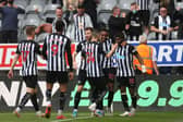 Joe Willock of Newcastle United celebrates with team mates Miguel Almiron and Allan Saint-Maximin after scoring his team's first goal during the Premier League match between Newcastle United and Sheffield United at St. James Park on May 19, 2021 in Newcastle upon Tyne, England.