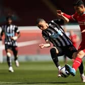 Miguel Almiron of Newcastle United is challenged by Ozan Kabak of Liverpool during the Premier League match between Liverpool and Newcastle United at Anfield on April 24, 2021 in Liverpool, England.