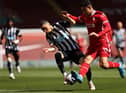 Miguel Almiron of Newcastle United is challenged by Ozan Kabak of Liverpool during the Premier League match between Liverpool and Newcastle United at Anfield on April 24, 2021 in Liverpool, England.