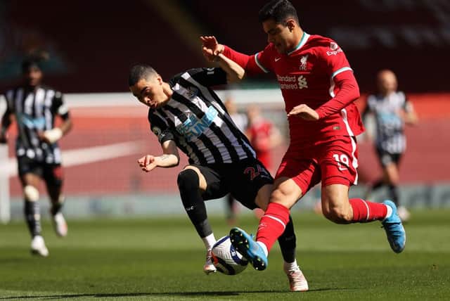 Miguel Almiron of Newcastle United is challenged by Ozan Kabak of Liverpool during the Premier League match between Liverpool and Newcastle United at Anfield on April 24, 2021 in Liverpool, England.