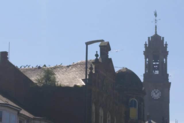 The roof damage is prominent on the town's skyline.