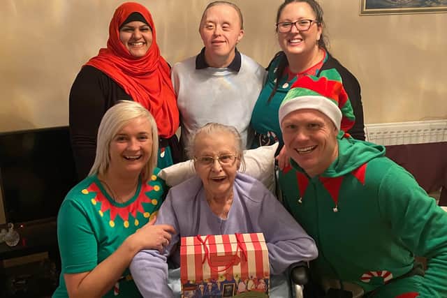 Customers receiving presents from staff at Bluebird Care dressed as elves