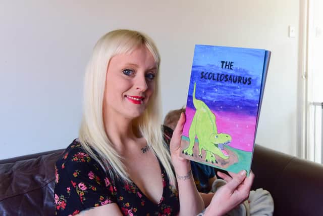 Lauren Davis with her book which is based on her own experiences with scoliosis.